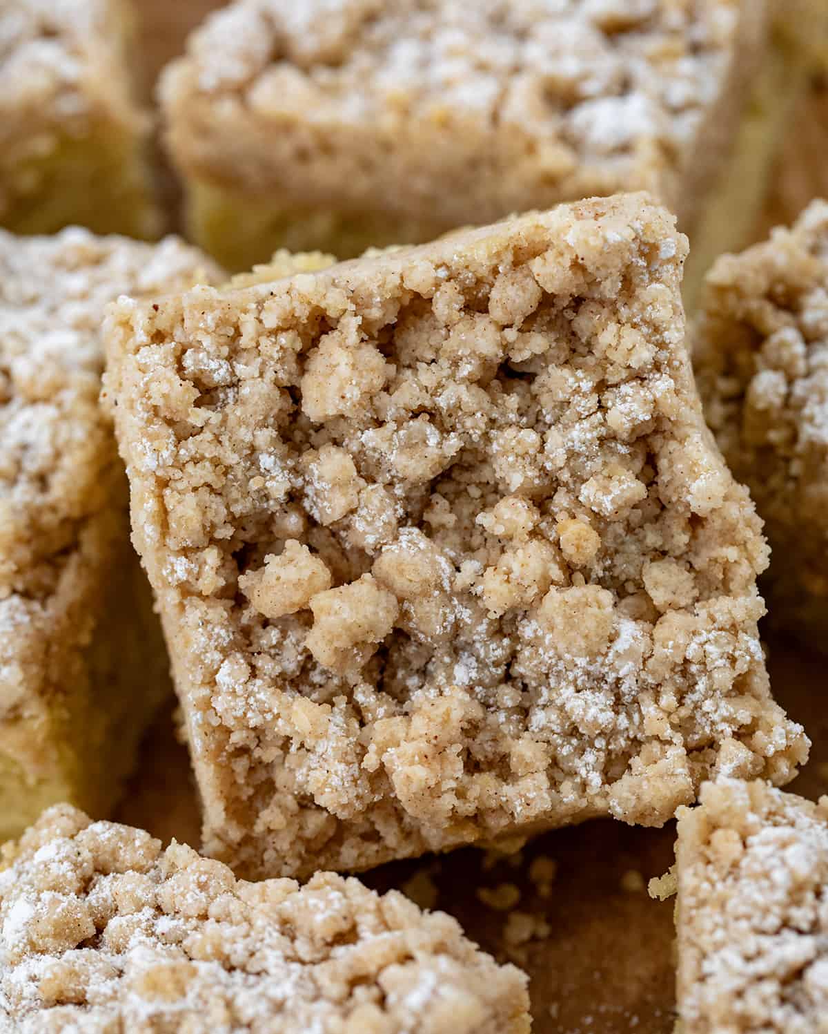 CLose up of a piece of Banana Crumb Cake surrounded by more.