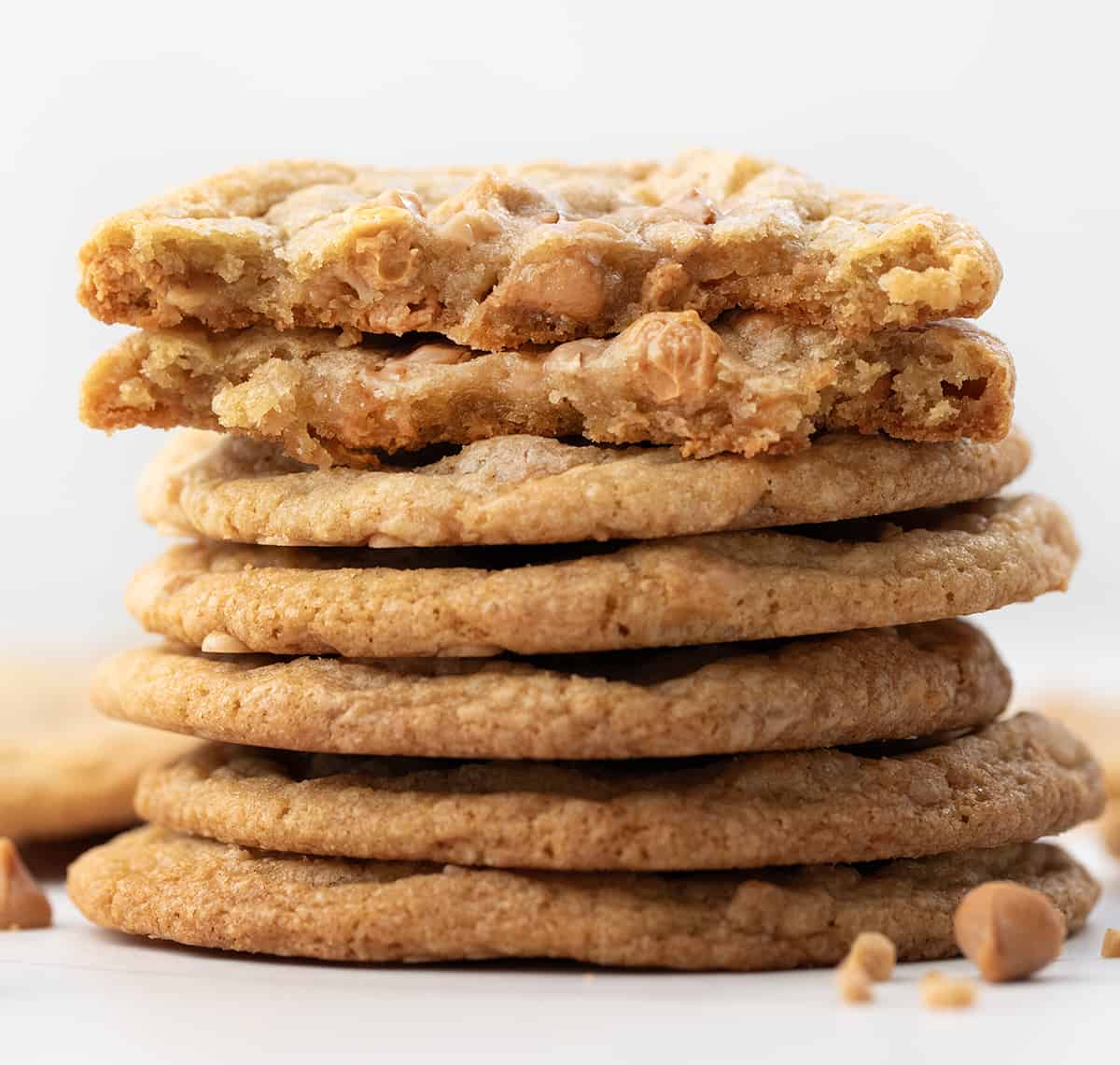 Stack of Butterscotch Toffee Cookies with top cookie halved showing inside texture.