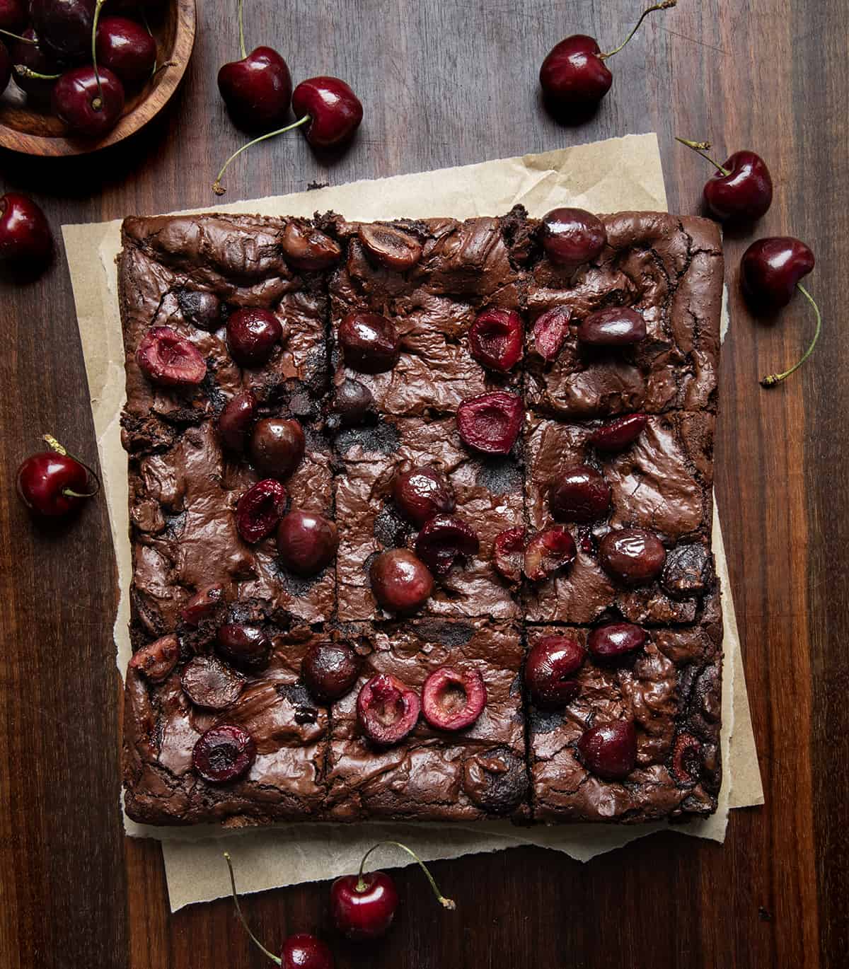 Pan of Roasted Cherry Brownies on a dark wooden table from overhead.