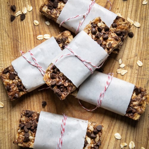 Individually wrapped No Bake Chewy Granola Bars on a wooden table.