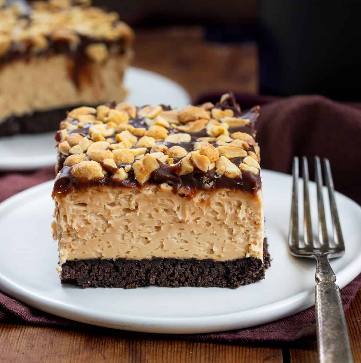 No Bake Buckeye Cheesecake Bar piece on a white plate with a fork.