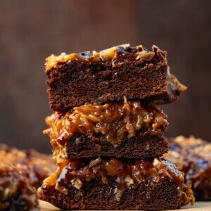 Stack of Toasted Coconut Brownies on a wooden table.