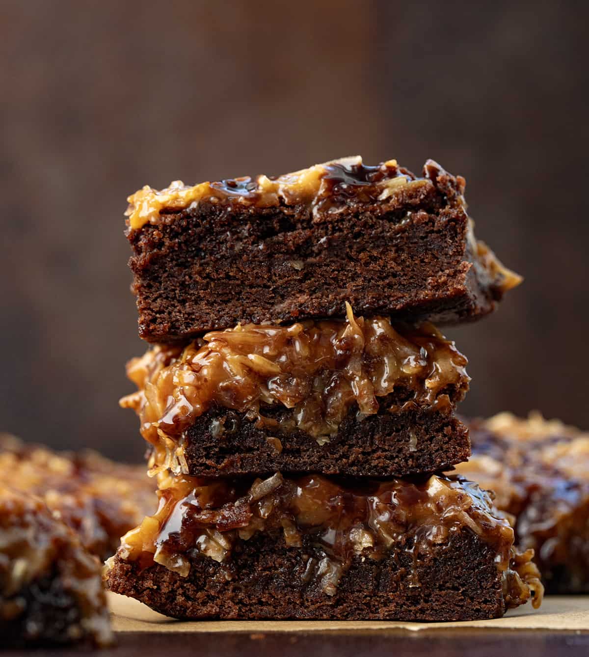 Stack of Toasted Coconut Brownies on a wooden table. 