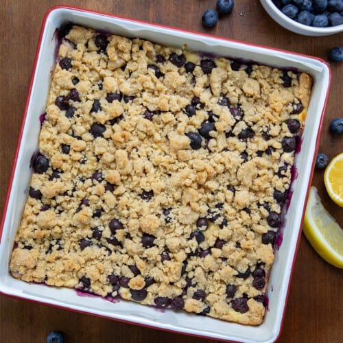 Blueberry Lemon Cheesecake Bars in a pan on a wooden table from overhead.