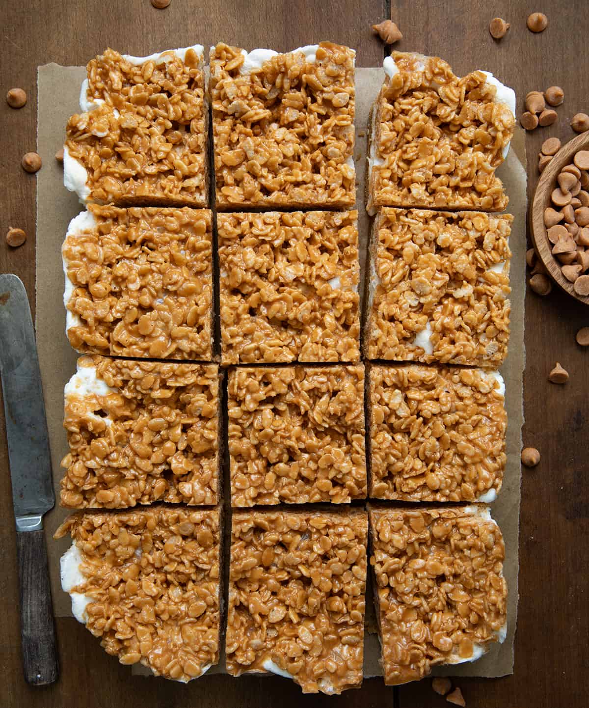 Butterscotch Bars on a piece of parchment paper on a wooden table cut into squares. 