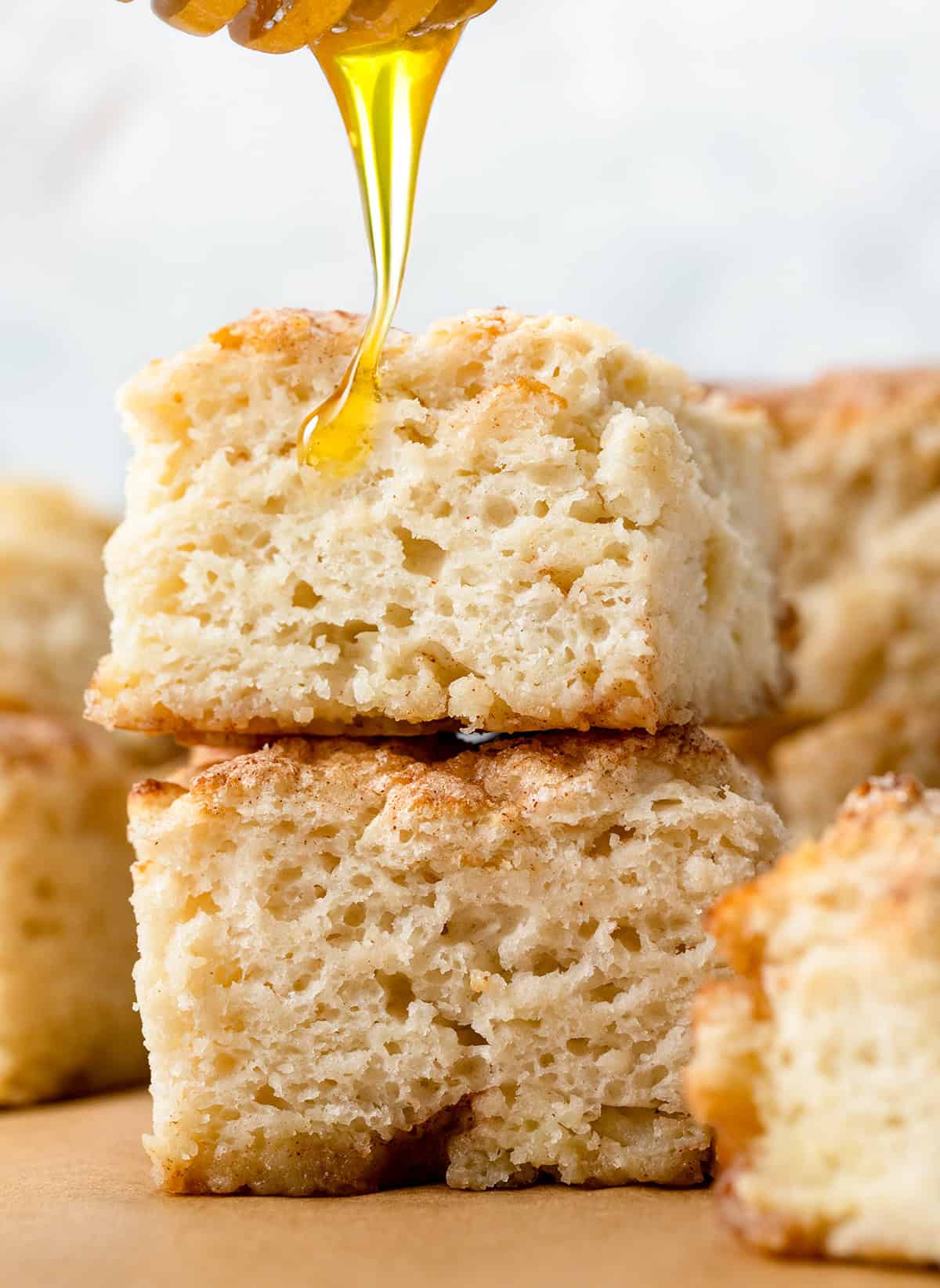 Drizzling honey over a Cinnamon Honey Butter Swim Biscuit.