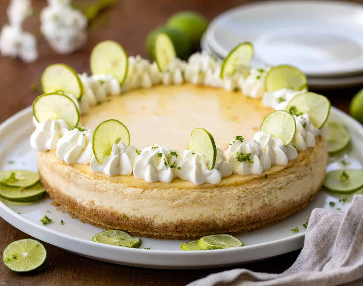 Key Lime Cheesecake on a white serving platter on a wooden table.