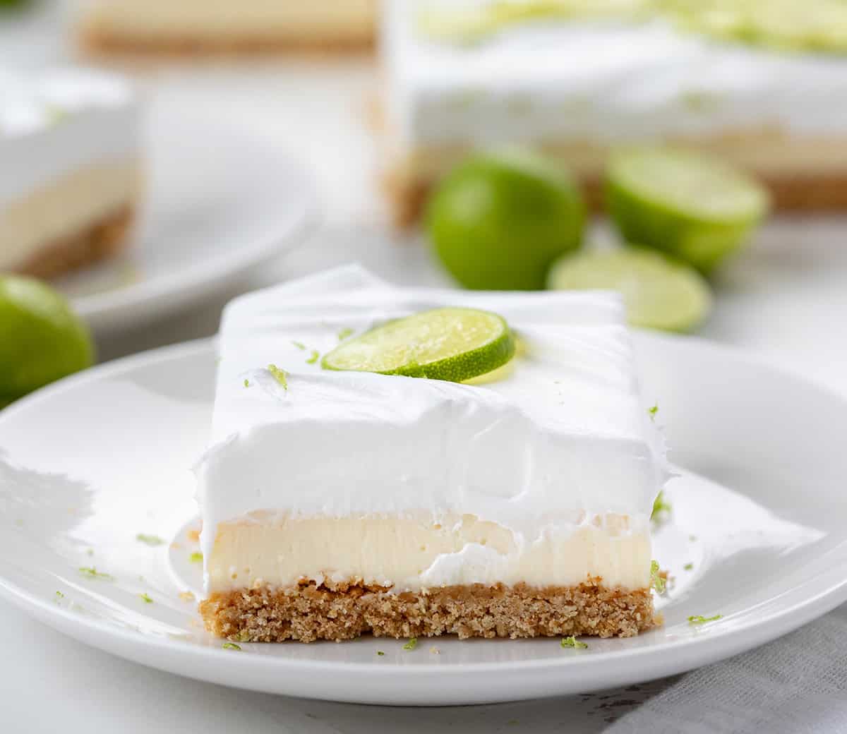 One Key Lime Pie Bar on a white plate on a white counter.