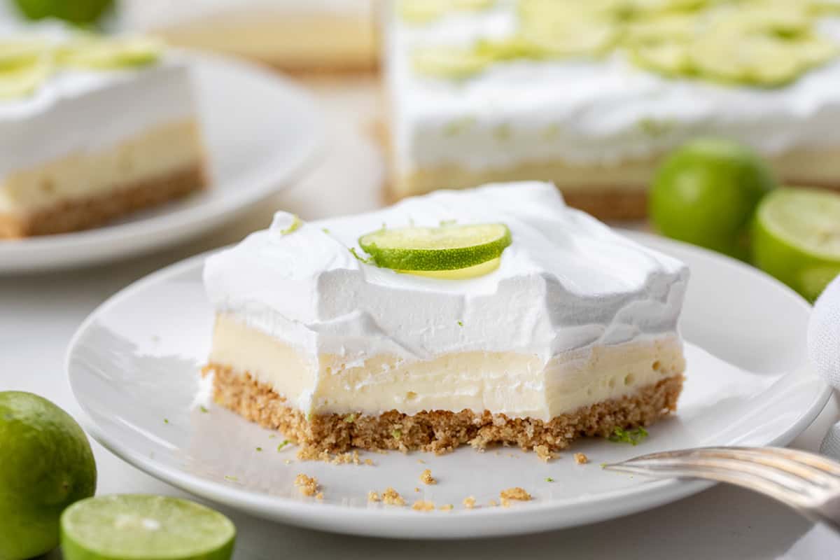Key Lime Pie Bar on a white plate with a bite removed showing inside texture.