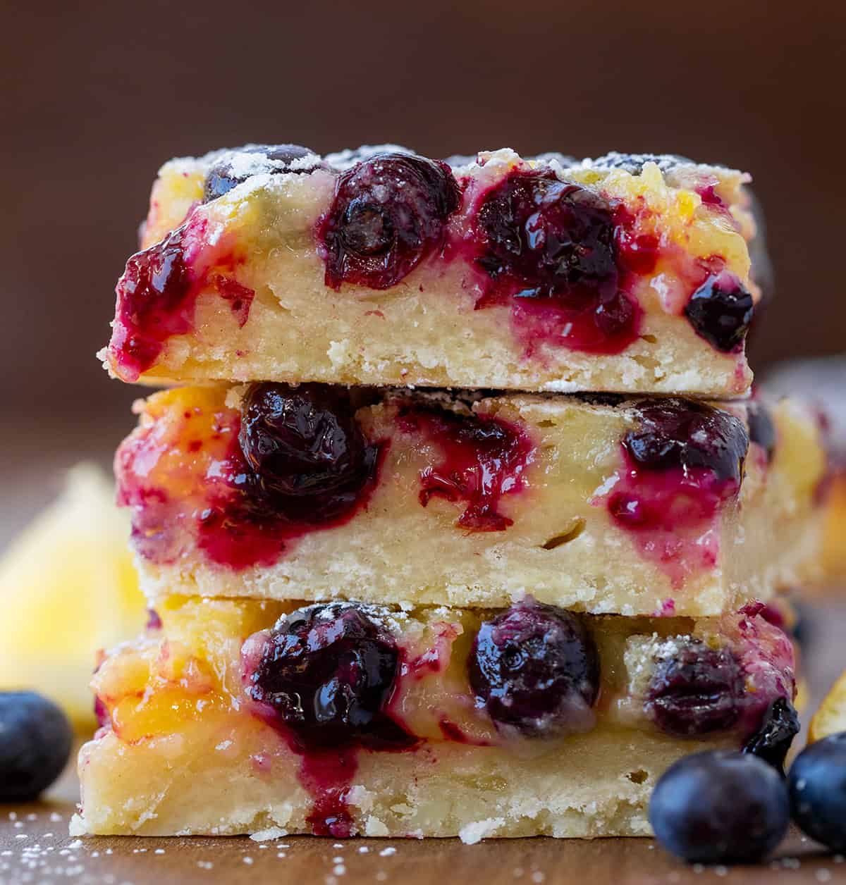Stack of Lemon Blueberry Bars on a wooden table.