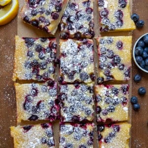 Lemon Blueberry Bars cut into pieces on a wooden table from overhead.