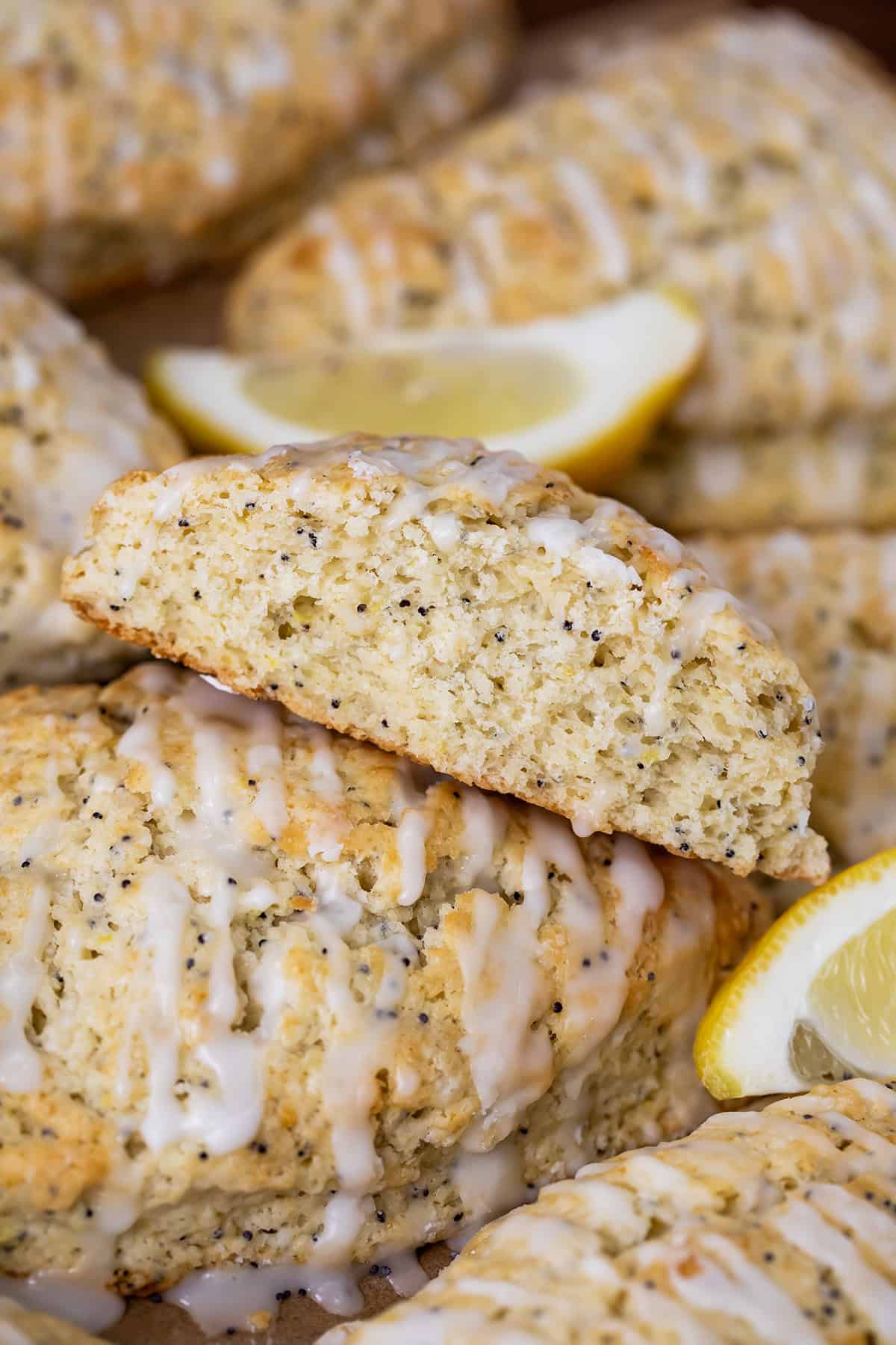 Lemon Poppy Seed Scones stacked closely together with one on its side showing inside texture of scone.