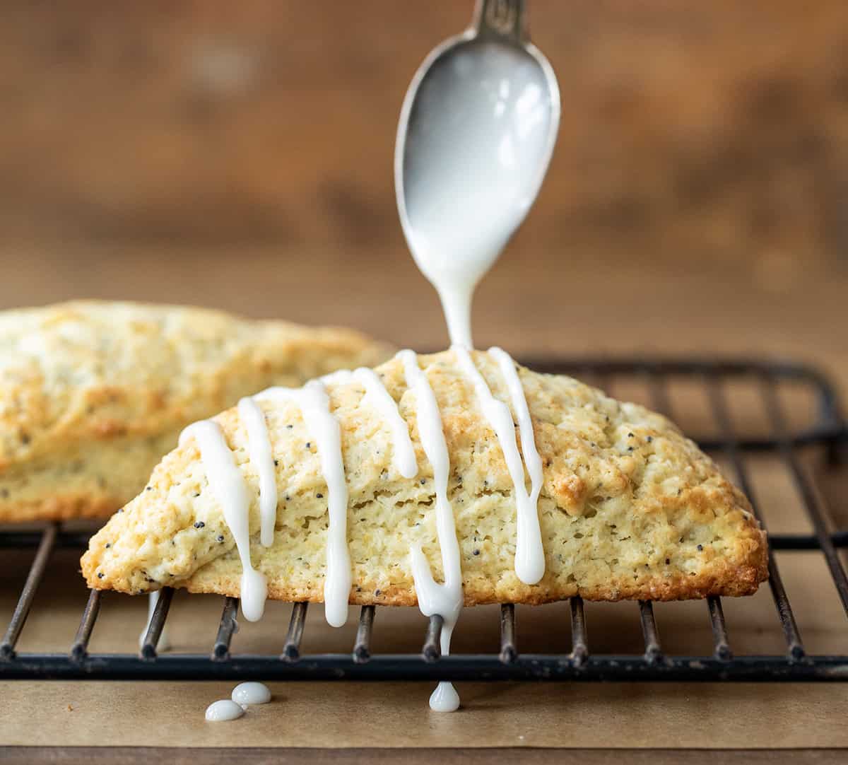 Drizzling vanilla glaze over the best lemon poppyseed scone.