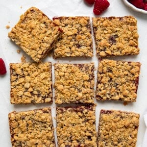 Raspberry Oatmeal Crumble Bars cut into squares on a white table from overhead.