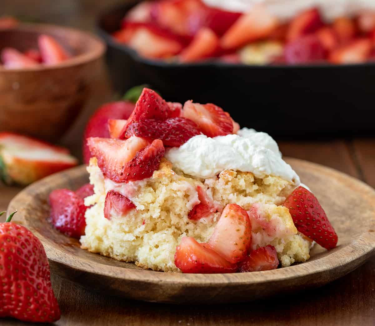 Plate of Skillet Strawberry Shortcake on a wooden table.