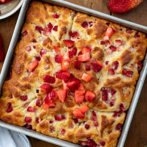 Strawberry Butter Swim Biscuits in a pan on a wooden table from overhead.