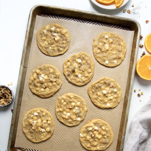 Sheet pan of White Chocolate Orange Cookies on a white table from overhead.