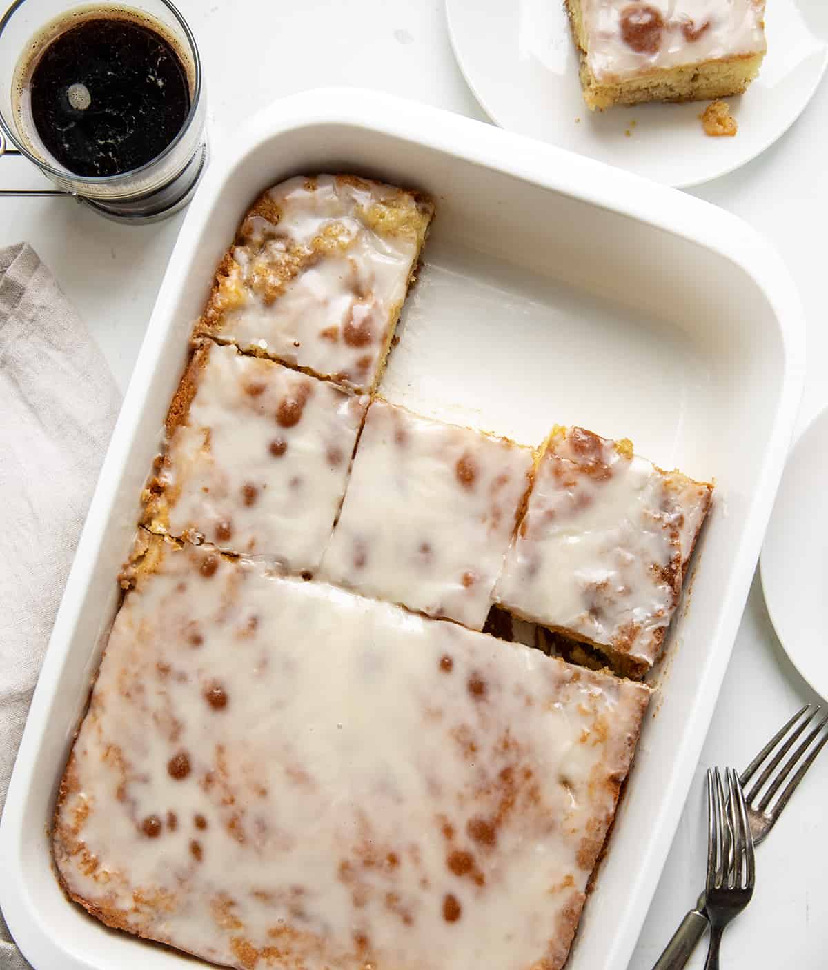 Honey Bun Cake in a pan with some pieces removed from overhead. 
