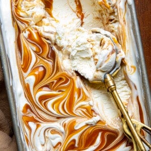 Pan of homemade No Churn Salted Caramel Ice Cream with an ice cream scoop in it filled with ice cram.