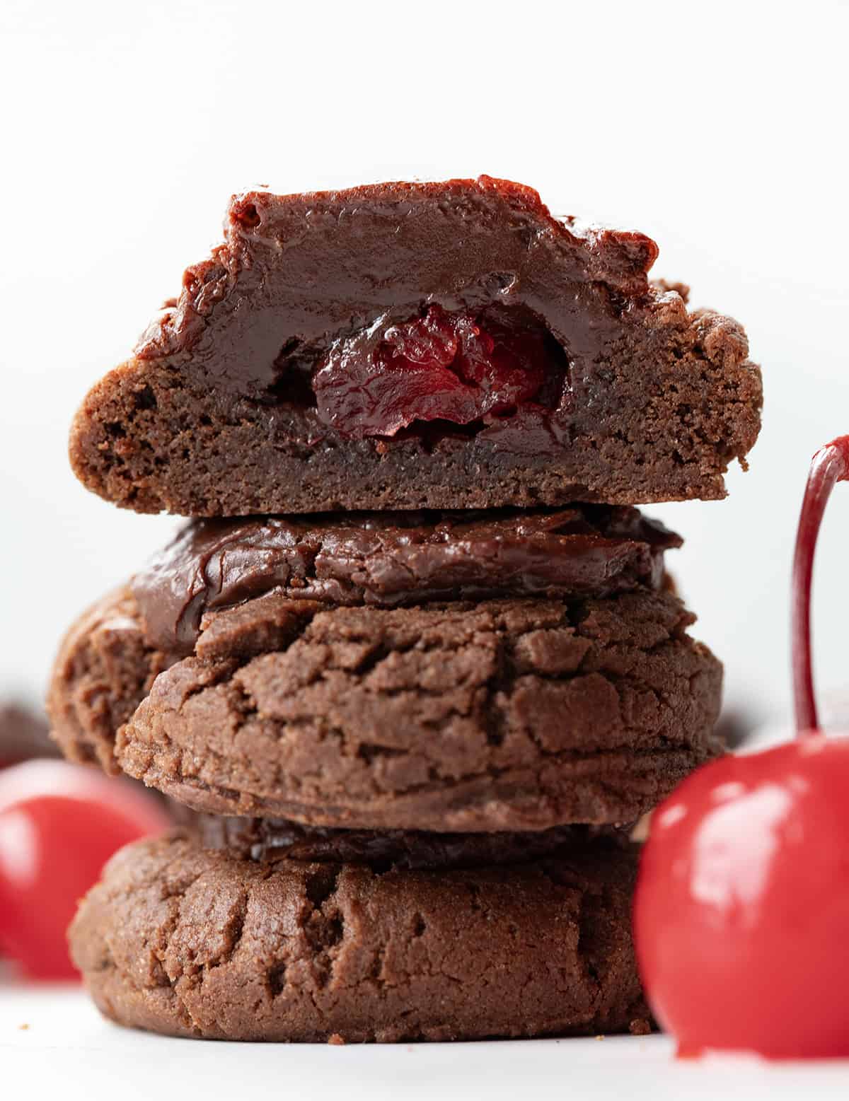 Stack of Chocolate Covered Cherry Cookies with top cookie cut in half.