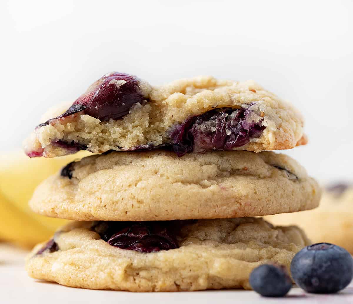 Stack of Lemon Blueberry Cookies with top cookie halved to show inside texture.