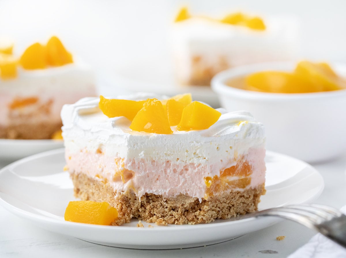 One piece of Peach Delight on a white plate with a bite removed and fork resting on the side of the plate.