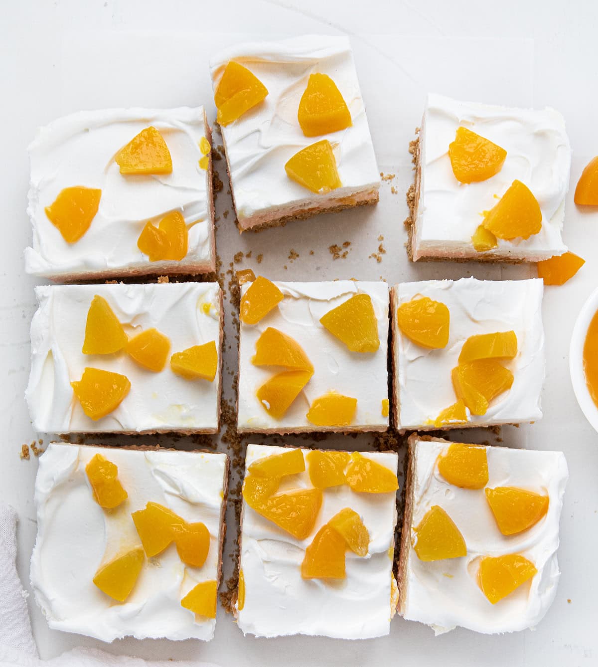 Peach Delight on a white table on a piece of white parchment cut into nine pieces and slightly separated. 