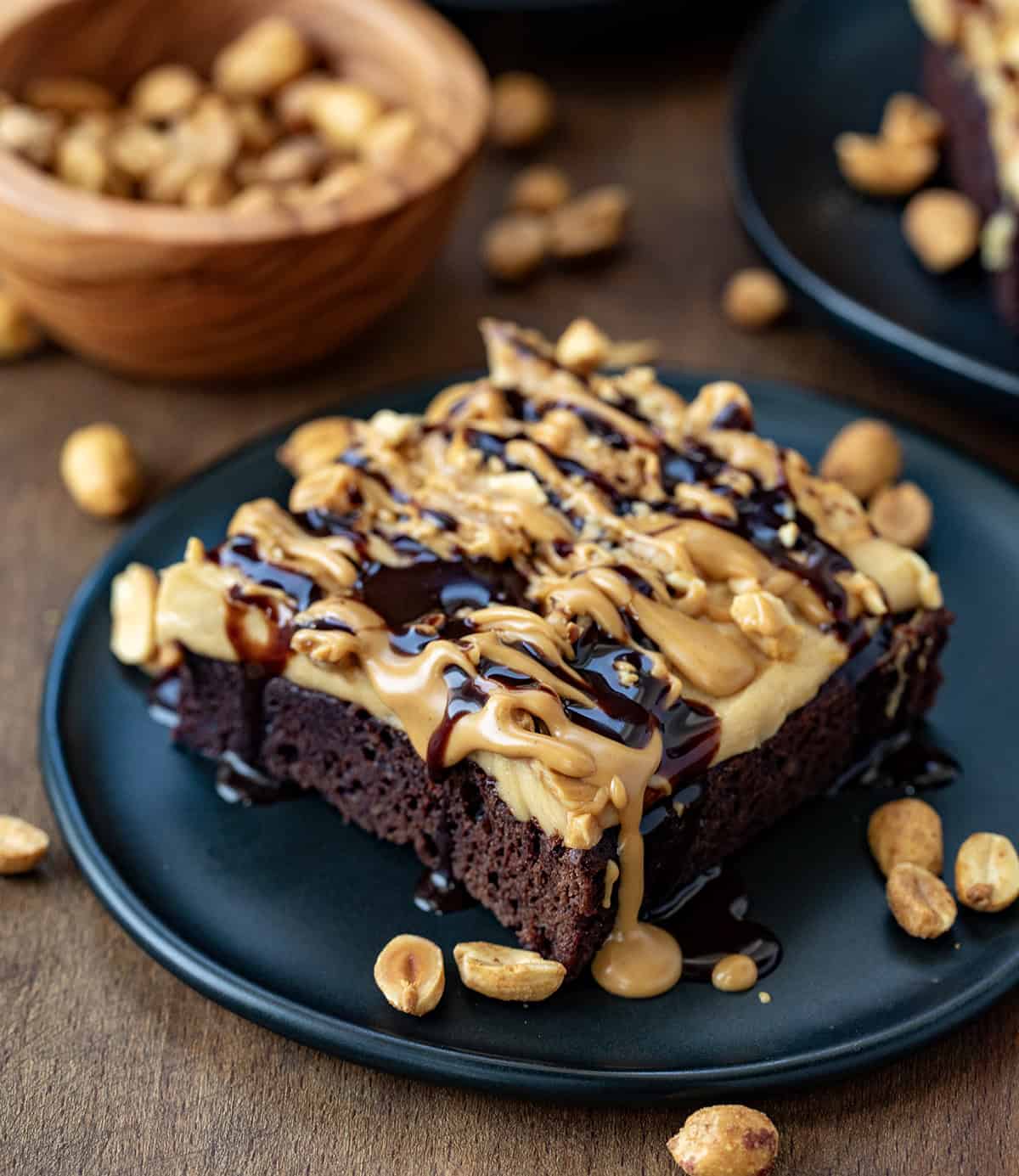 One Peanut Butter Mousse Brownie on a black plate with other brownies around.