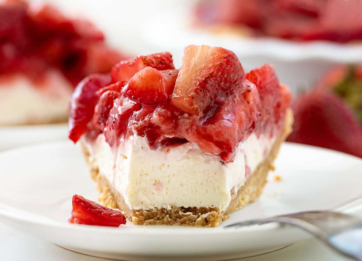 Piece of Strawberry Cream Cheese Pie on a plate with a bite removed showing the texture.