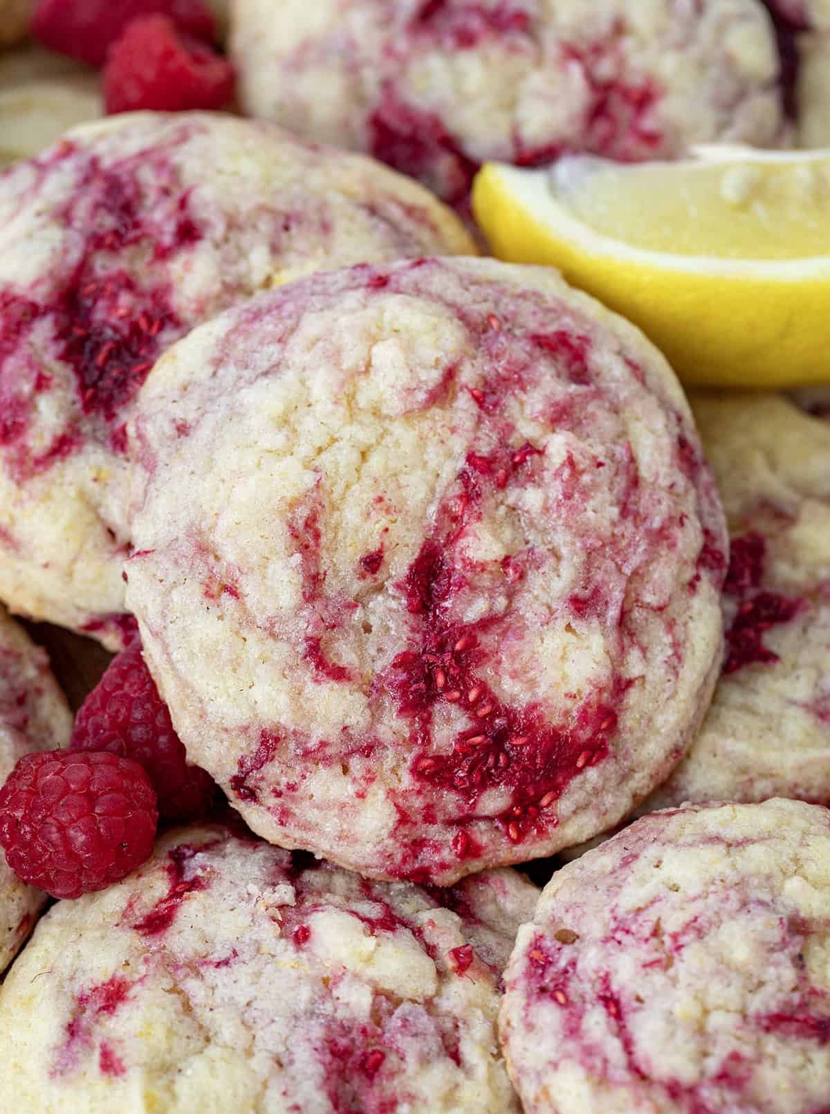 Close up of Lemon Raspberry Cookies stacked all together on a wooden table.