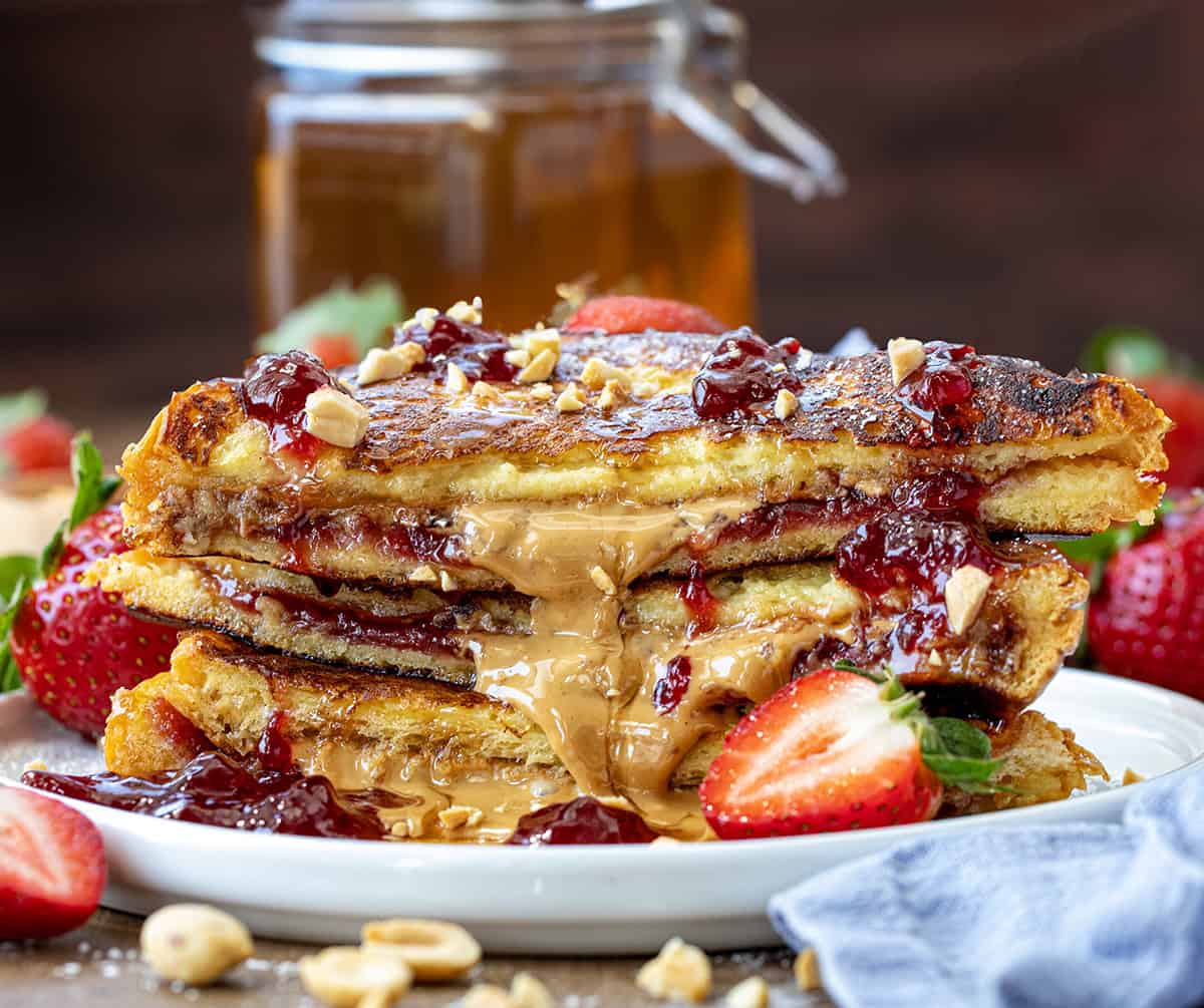 Cut in half and stacked Peanut Butter and Jelly French Toast on a plate showing inside texture.