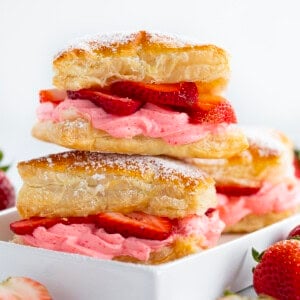 Strawberry Cheesecake Napoleon stacked on itself and dusted with confectioners sugar in a white dish.