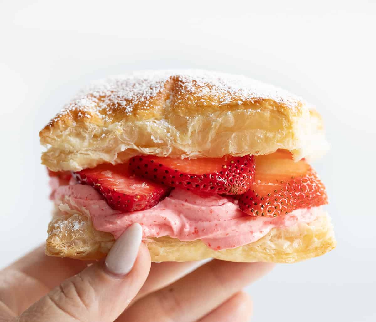 Hand holding a Strawberry Cheesecake Napoleon.