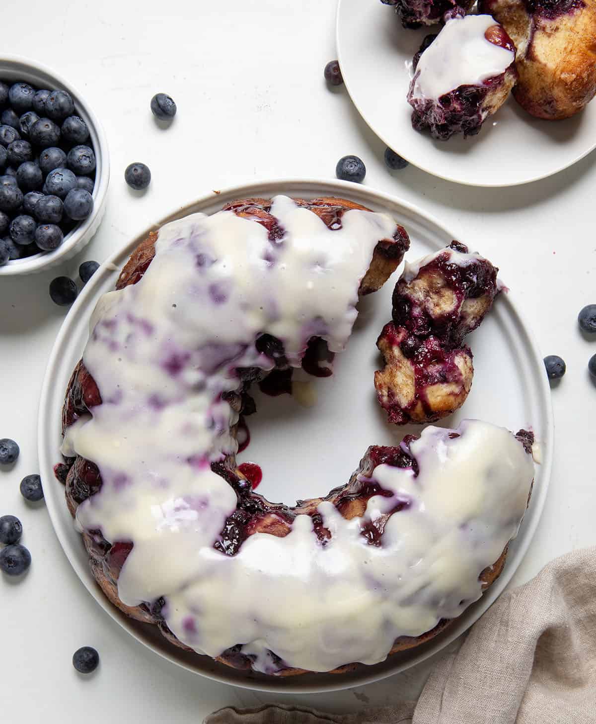Blueberry Monkey Bread on a white plate with a couple of pieces removed from overhead.