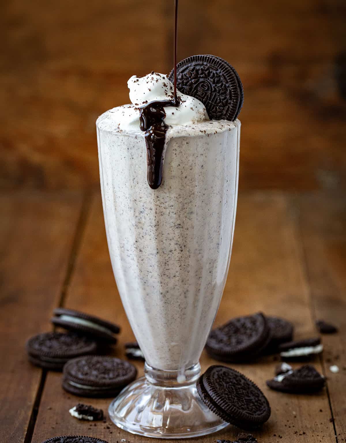 Drizzling hot fudge onto an Oreo Milkshake.