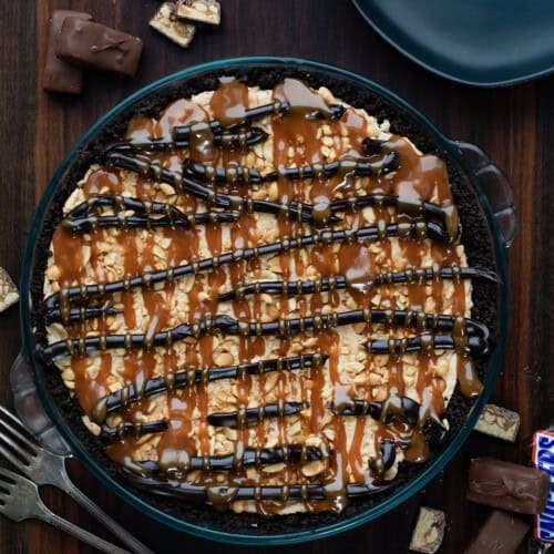 Whole Snickers Pie on a wooden table from overhead.
