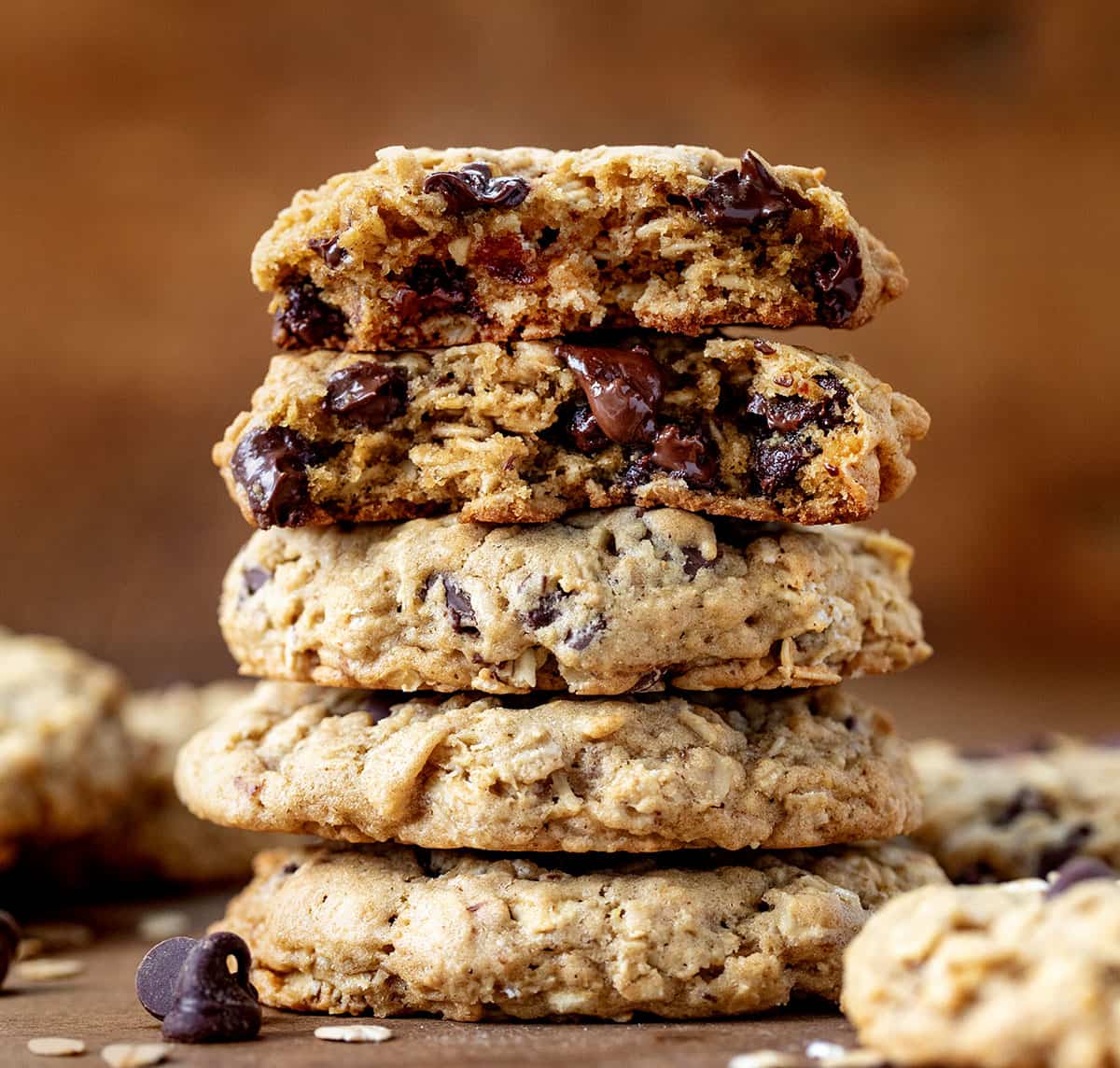 Stack of Brown Butter Oatmeal Chocolate Chip Cookies with the top cookie halved showing inside texture.