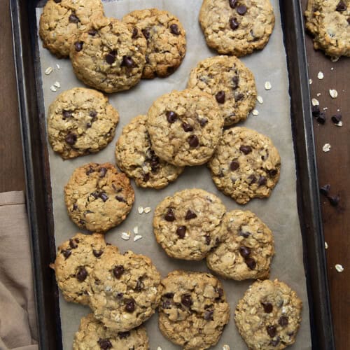 Brown Butter Oatmeal Chocolate Chip Cookies on a tray on a wooden table from overhead.