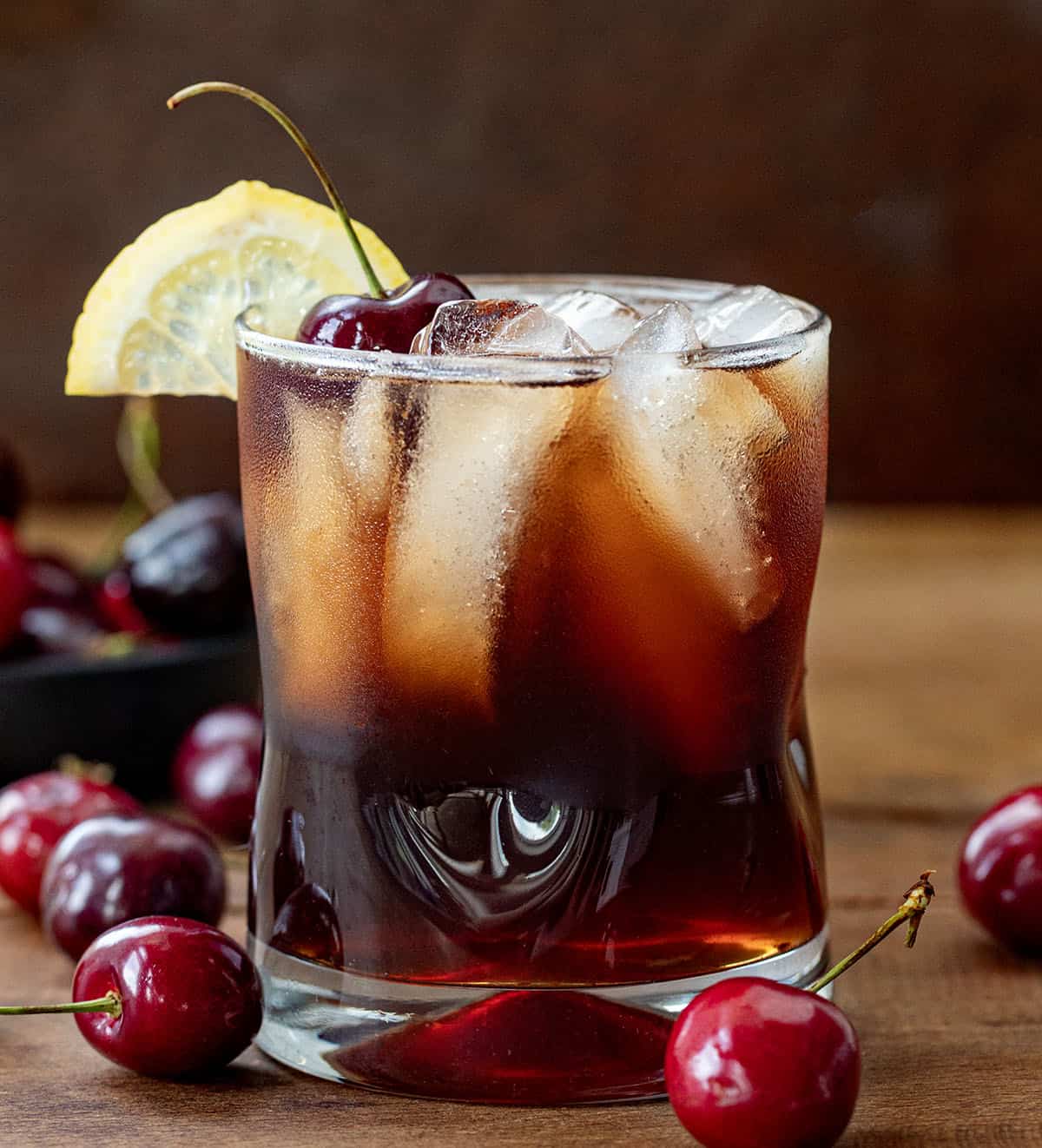 Glass of Cherry Bounce on a wooden table.