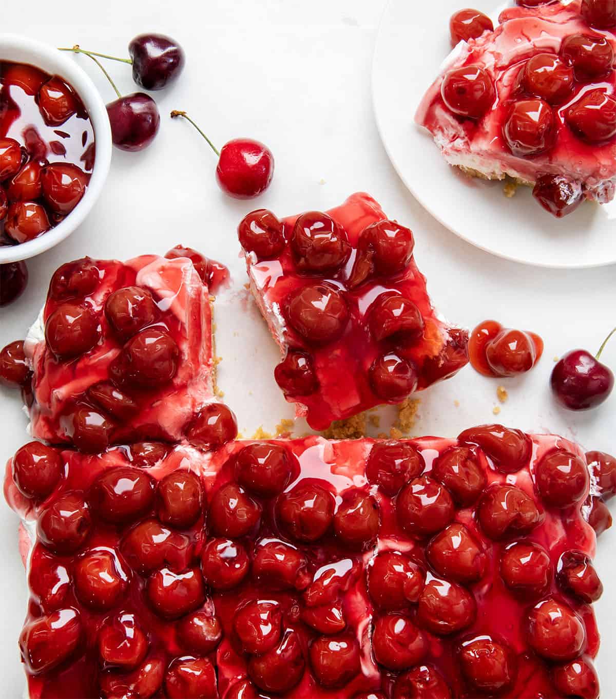 Cherry Delight bars on a white table with some bars cut and separated from the rest from overhead.