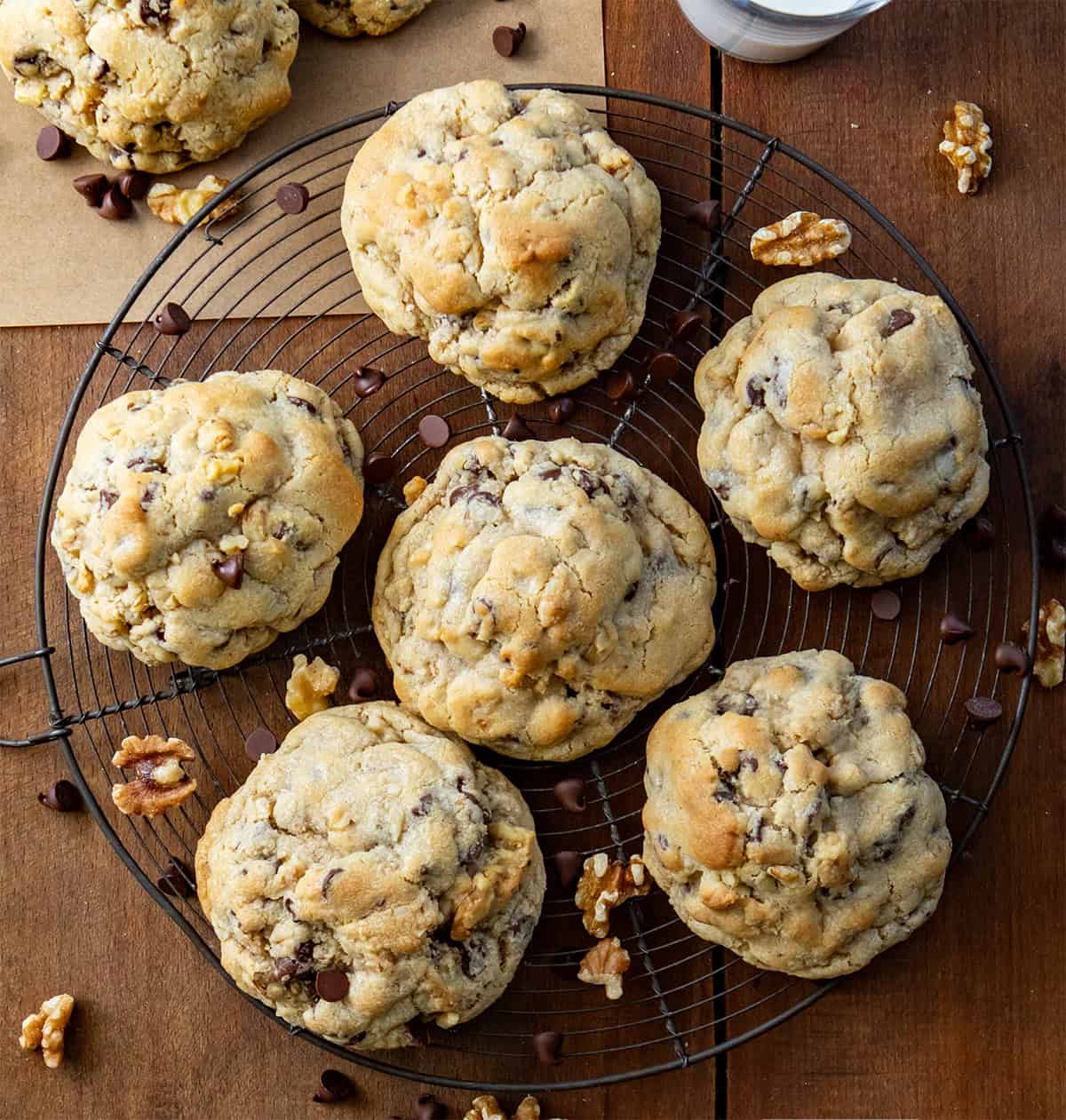 Rack of Copycat Levain Bakery Chocolate Chip Cookies or a chocolate chip walnut cookie on a wooden table with a glass of milk from overhead.