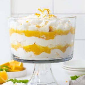 Creamsicle Trifle on a white counter surrounded by oranges and mint.