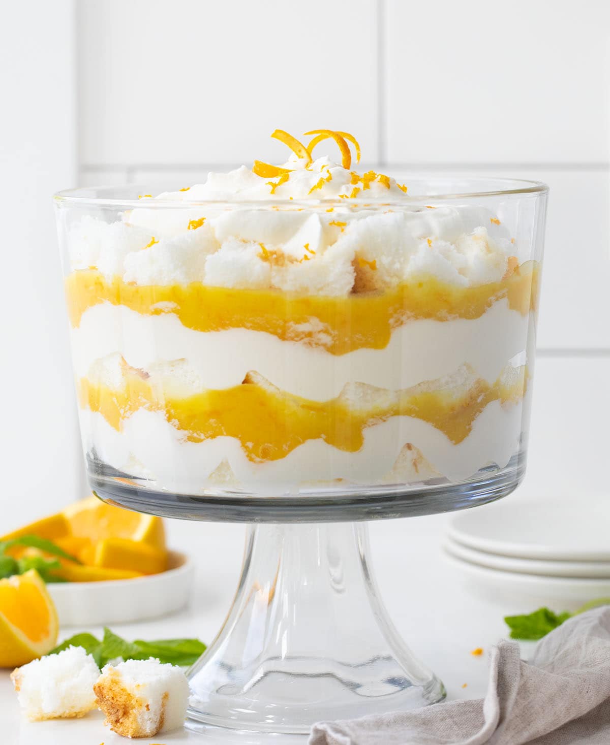 Creamsicle Trifle on a white counter surrounded by oranges and mint.