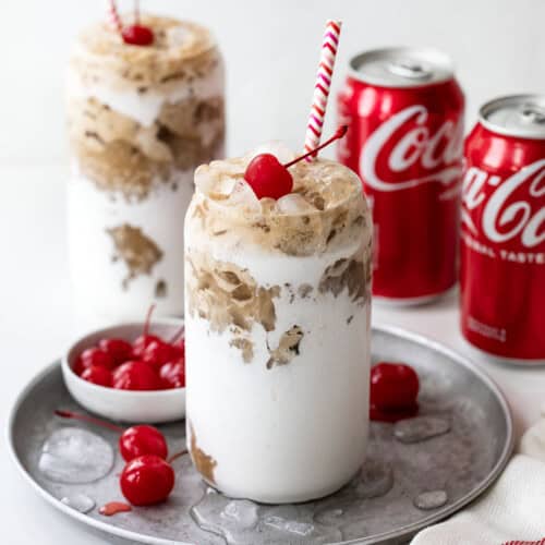 Fluffy Cokes on a white table top with cans of Coca Cola.