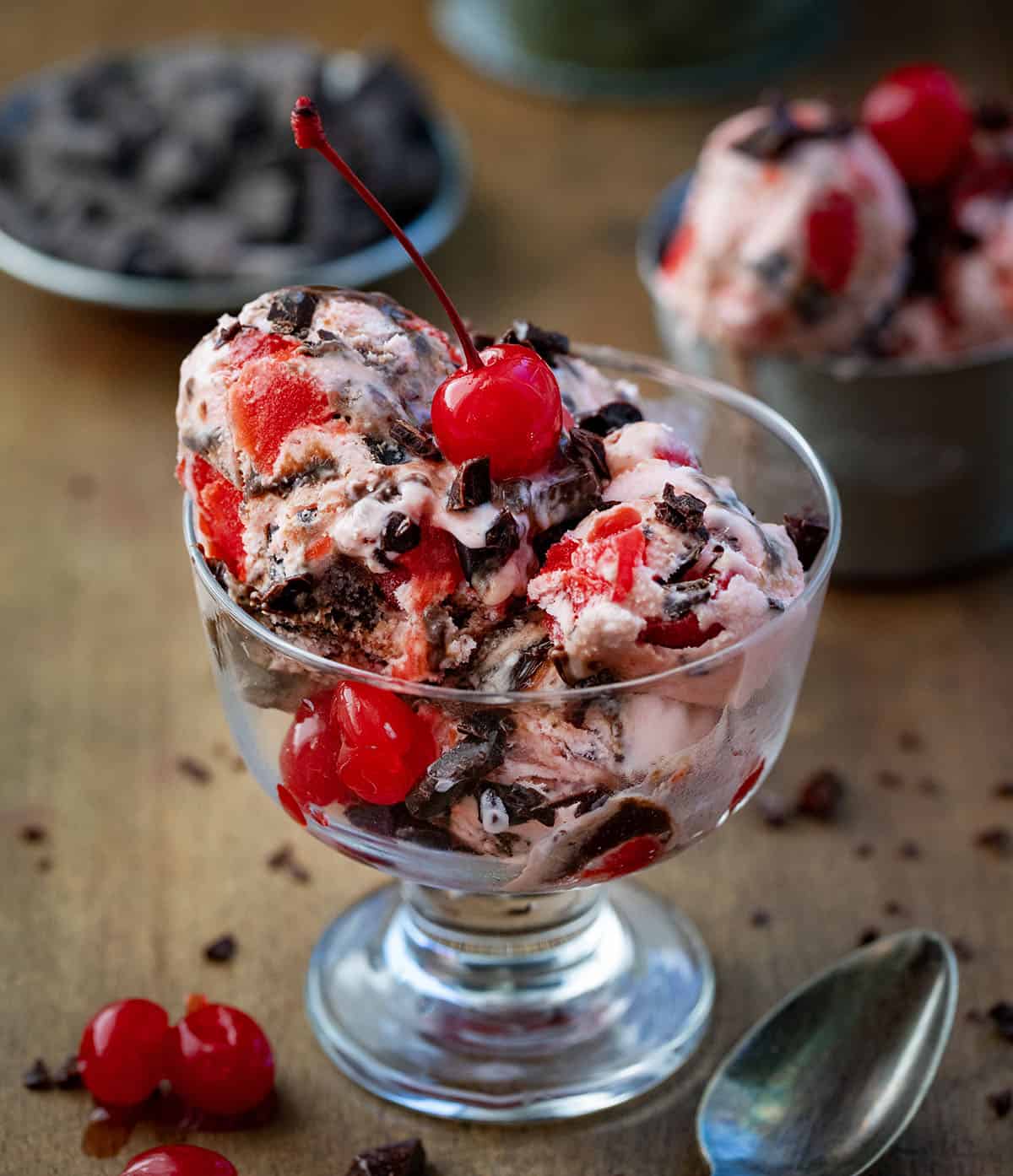 Cup of Chocolate Cherry Ice Cream with spoons and cherries.