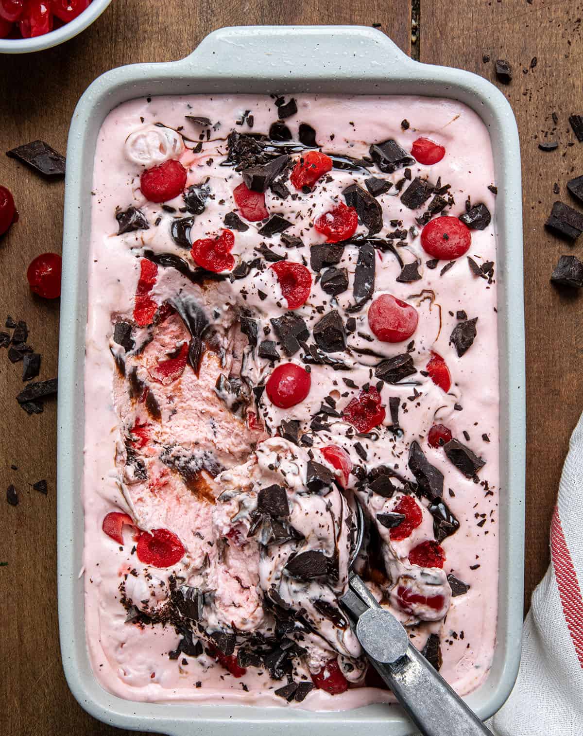 Pan of Chocolate Cherry Ice Cream with one scoop removed from overhead. 