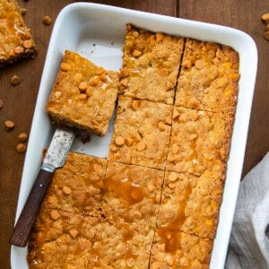 Oatmeal Butterscotch Bars in a pan with one bar removed and another about to be removed.