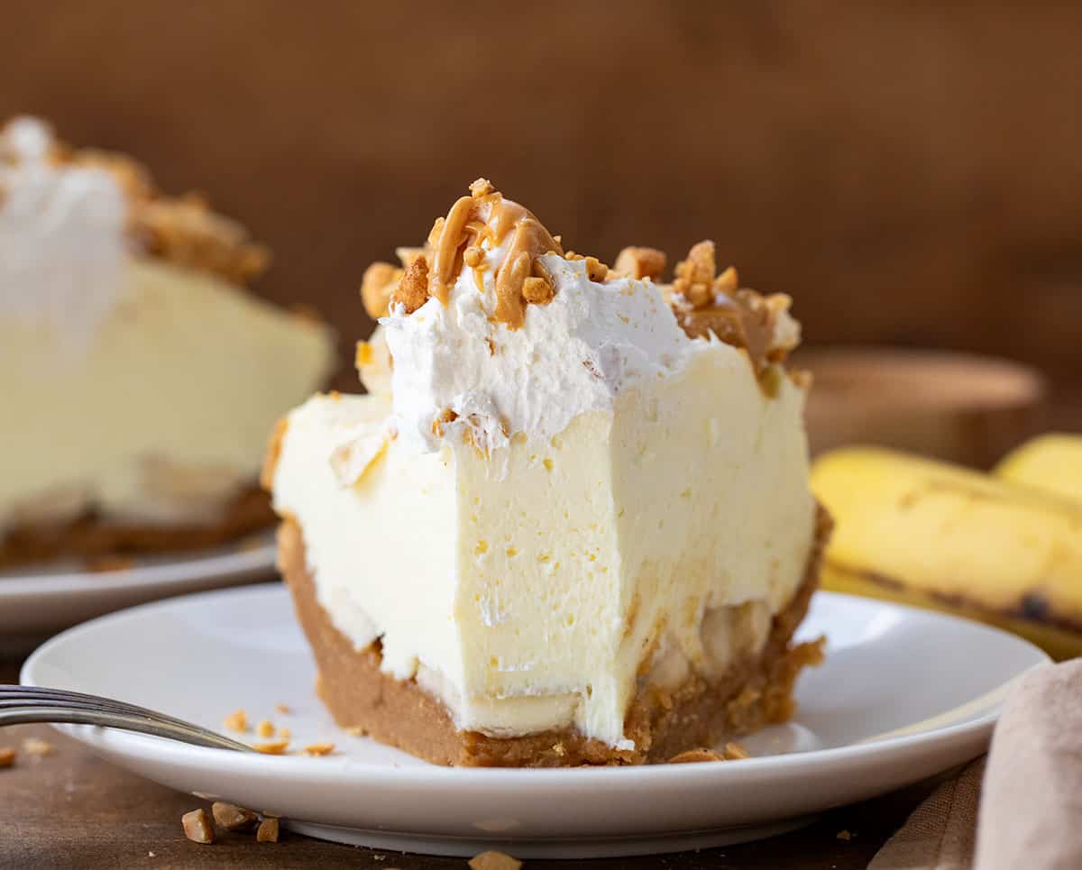 Slice of Peanut Butter Banana Cream Pie on a white plate with a bite taken out of it.