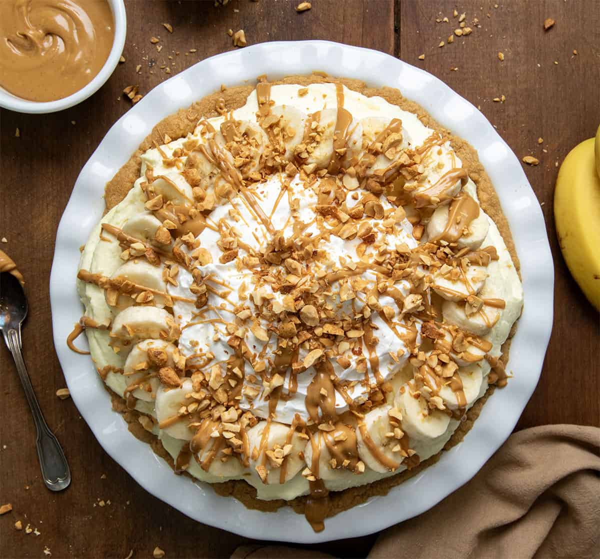 Peanut Butter Banana Cream Pie on a wooden table from overhead.