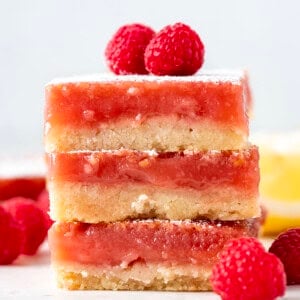 Stack of Raspberry Lemon Bars on a white table looking straight on.